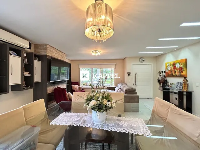 Sala de estar com sofá e televisão em ambiente bem iluminado.