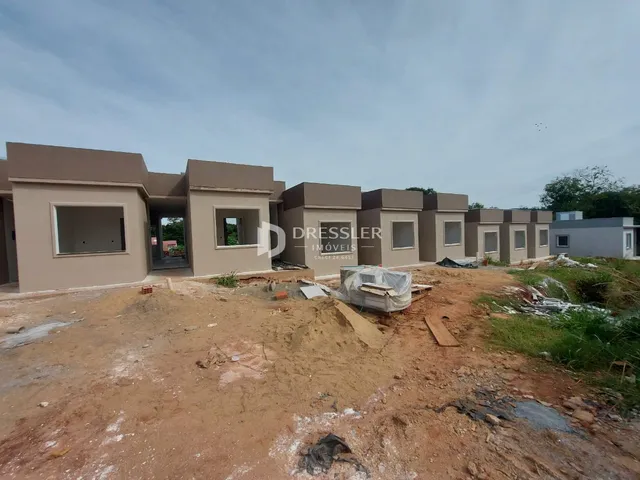 Fachada de casas em construção em Lajeado, Brasil, com terreno irregular.