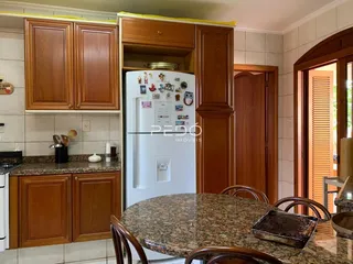 Foto de uma cozinha com armários de madeira e uma mesa de jantar.