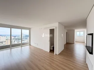 Sala de estar com piso de madeira e vista panorâmica da cidade.