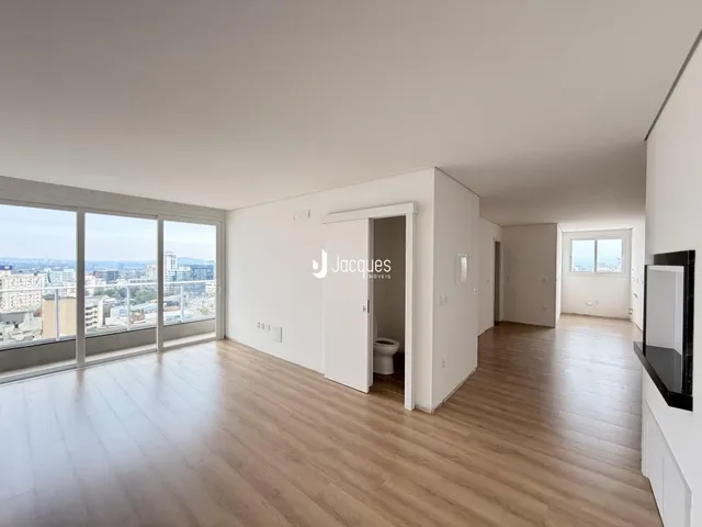 Sala de estar com piso de madeira e vista panorâmica da cidade.