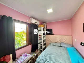 Quarto com cama e janela com vista para a vegetação externa.