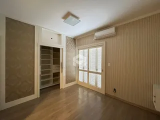 Sala com piso de madeira e janela de boa iluminação.