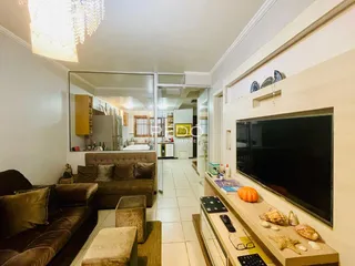 Sala de estar com sofá e televisão em um imóvel no Brasil.