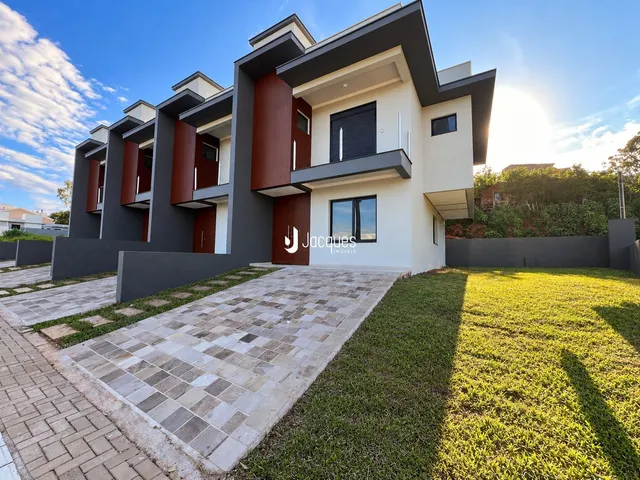 Fachada moderna de uma casa em Lajeado, Brasil, com revestimento em cinza escuro e detalhes em madeira.