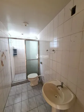Foto de um banheiro interno com revestimento de azulejos brancos.