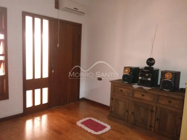 Hall de entrada com piso de madeira e porta de madeira.