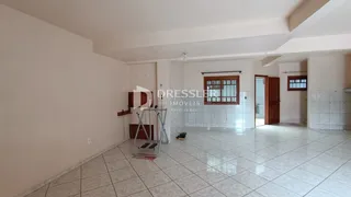 Interior de uma sala ampla com piso de cerâmica clara.