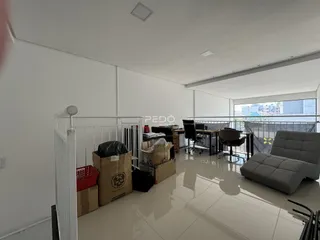 Interior de uma sala ampla com piso de cerâmica e vista para a varanda.