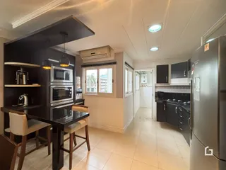 Cozinha moderna com ilha e eletrodomésticos em um apartamento.