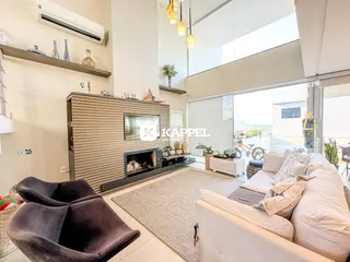 Sala de estar moderna com lareira e grande abertura para a vista.