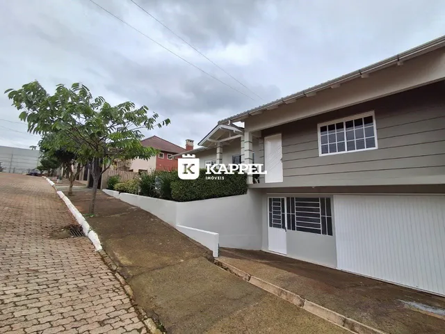 Fachada de uma residência em Lajeado, Brasil, mostrando a garagem e o jardim lateral.