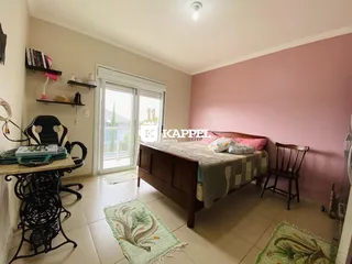 Este quarto apresenta uma cama de madeira e uma área de trabalho.