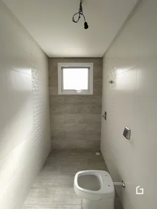 Hall de corredor interno com paredes brancas e piso claro.