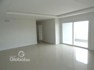 Ambiente interno de uma sala ampla com paredes brancas e piso claro.