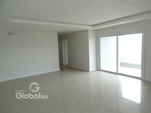 Ambiente interno de uma sala ampla com paredes brancas e piso claro.
