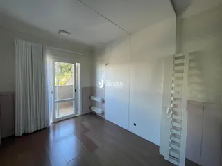 Interior de uma sala com piso de madeira e porta de vidro.