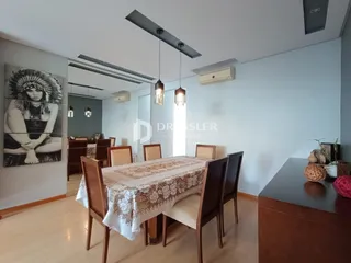 ambiente interno com mesa de jantar de madeira e piso claro