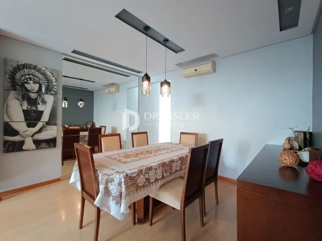 ambiente interno com mesa de jantar de madeira e piso claro