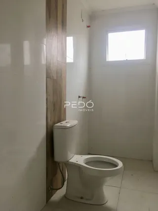 Foto de um banheiro com vaso sanitário e parede branca em uma residência.