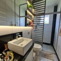 Foto de um banheiro interno com revestimento de azulejos brancos e uma pia.