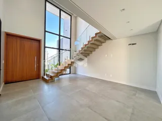 Ambiente interno de uma casa moderna com grande janela e escadaria.