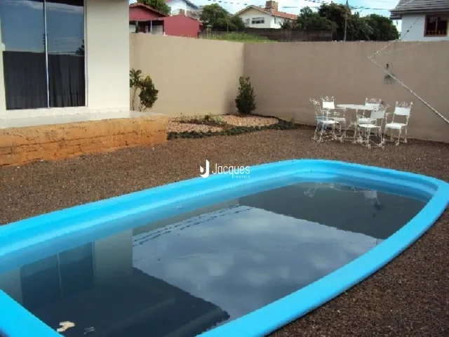 A foto mostra uma piscina externa em uma propriedade.