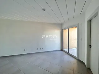 Ambiente interno de uma sala com piso de cerâmica e paredes brancas.