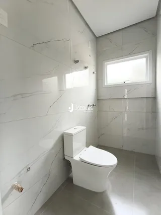Foto de um banheiro com revestimento em mármore branco.