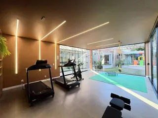 Imagem de uma área comum moderna com esteiras e vista para o exterior.