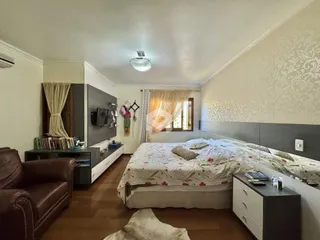 Quarto com cama e televisão em um apartamento no Brasil.