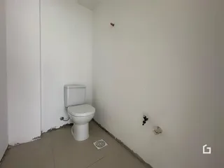 Foto de um banheiro com piso de concreto aparente e azulejo no chão.