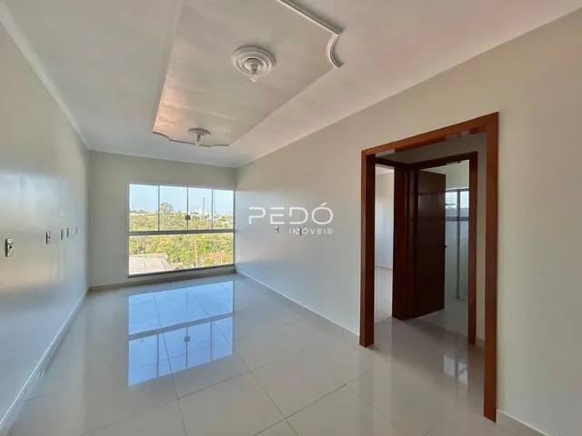 Sala de estar com piso de cerâmica e grande janela de vista para a natureza.
