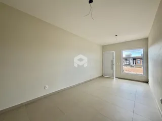 Sala de estar ampla com paredes brancas e piso claro.