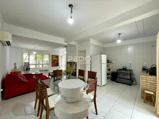 Sala de estar e jantar com piso de cerâmica e móveis de madeira.