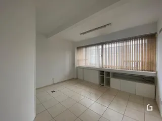 Ambiente interno de uma sala com piso de cerâmica e janela grande.
