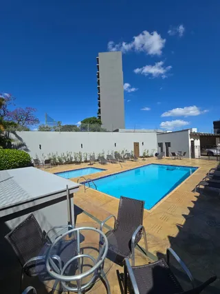 Foto de uma piscina externa com espreguiçadeiras em um imóvel.