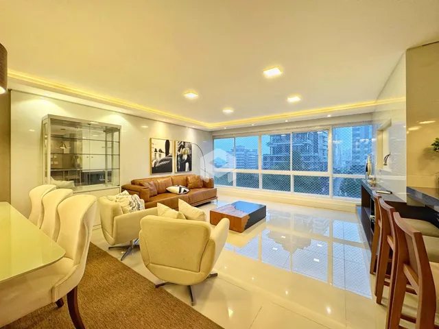 Sala de estar iluminada com vista para a paisagem urbana.