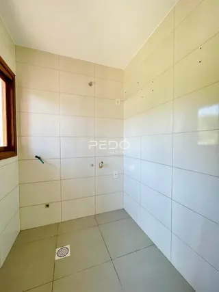 Interior de um banheiro com revestimento cerâmico branco.