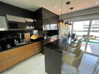 Vista da cozinha moderna com ilha e bancadas escuras.
