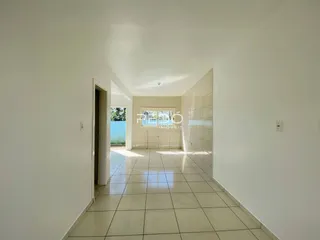 Corredor interno com paredes brancas e piso de cerâmica em uma residência.
