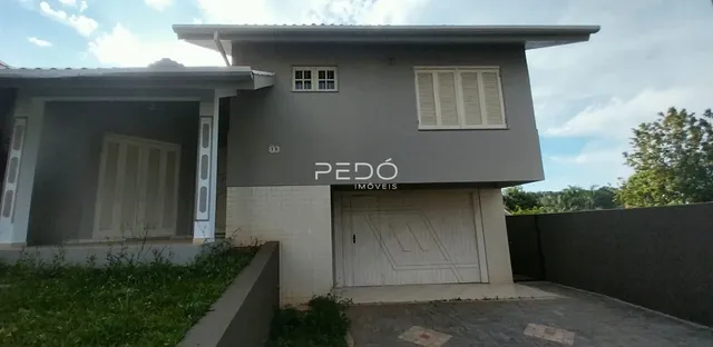 A fachada de uma casa em Lajeado, Brasil, com paredes cinzas e detalhes brancos.