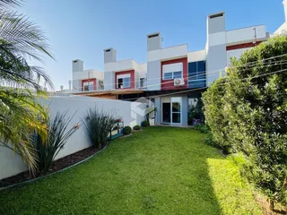 Fachada de uma residência moderna em Lajeado, Brasil, com jardim gramado na frente.
