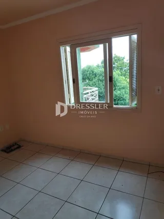 Vista interna de um cômodo com janela de grande porte em uma residência.