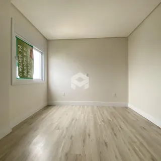 Sala de estar com piso de madeira clara e janela.