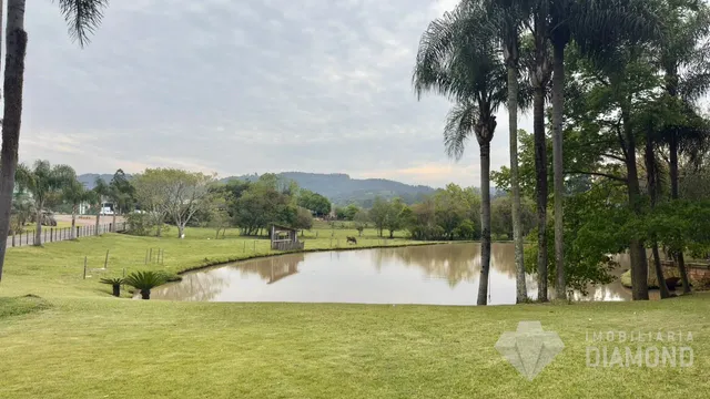 Paisagem de um terreno com gramado e corpo d'água em Lajeado.