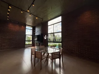 Ambiente interno com paredes de tijolo aparente e mesa de jantar de madeira.