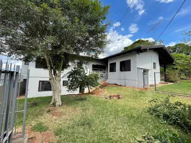 Vista externa de uma residência em Lajeado, Brasil, com jardim e árvore grande.