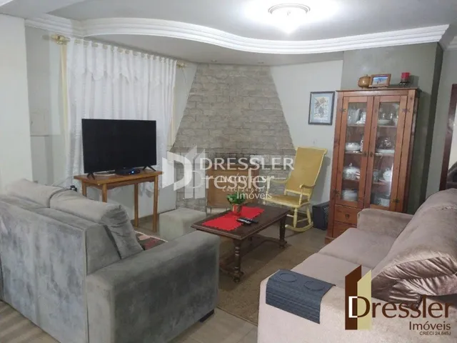 Sala de estar com sofá e televisão em um imóvel no Brasil.