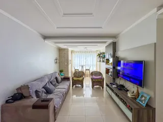 Sala de estar com sofá e decoração moderna em apartamento.